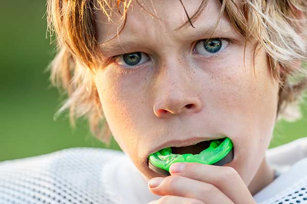 Zahnarztpraxis Dr. Molz - Junge spielt Football mit Sportmundschutz